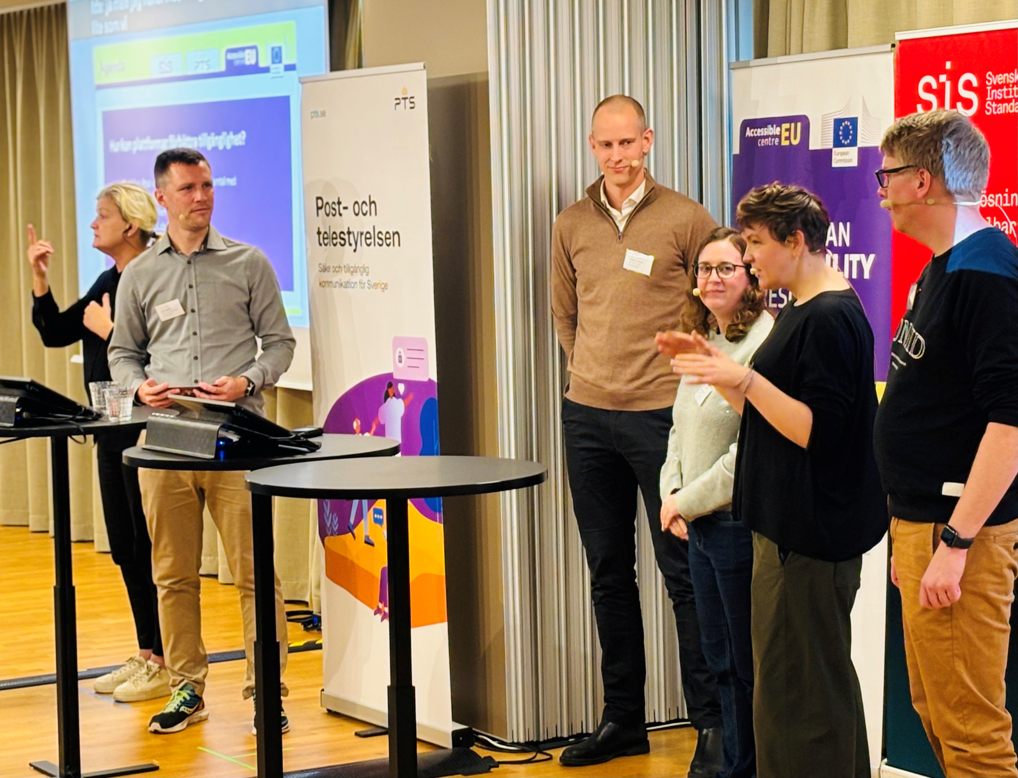 Sex personer står på en scen och samtalar under en konferens. I bakgrunden syns namnet Post- och telestyrelsen på en affisch.