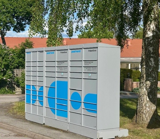 Bild på paketbox som står utomhus vid en trottoar