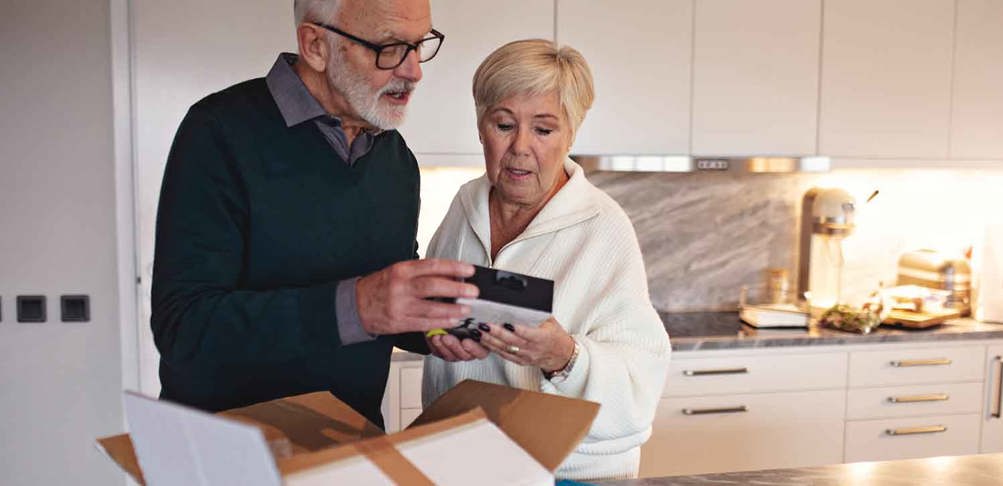 Äldre par granskar innehållet i ett nyöppnat paket.