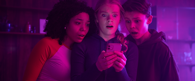 Ungdomar som tittar på en telefon.