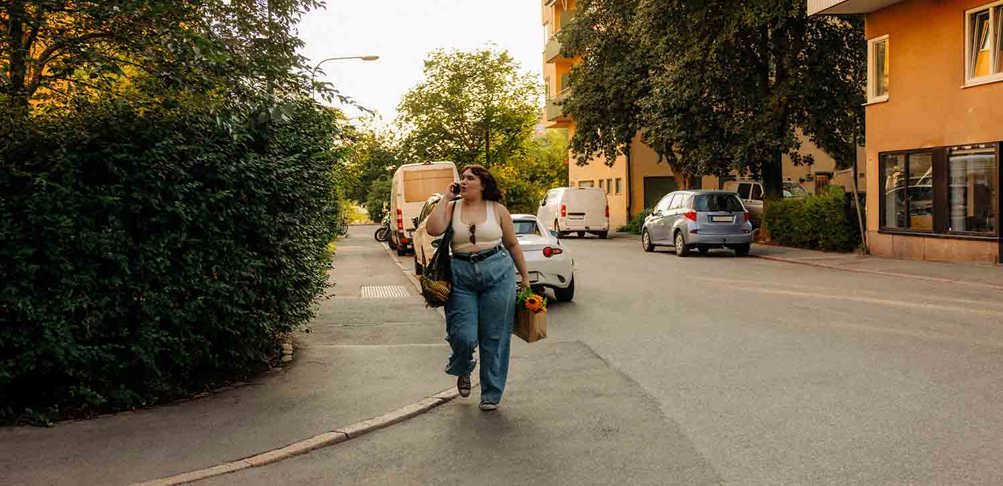 Kvinna går på gata och pratar i telefon.